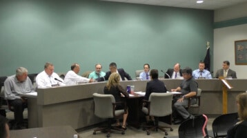 Council President Michael Tolmer shakes hands with new councilman Bert Cherry at the start of council's July 11, 2016 meeting.