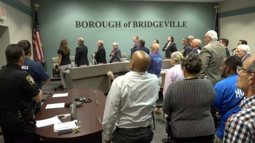 Borough council meeting attendees stand for the pledge of allegiance at the September 2021 council meeting.